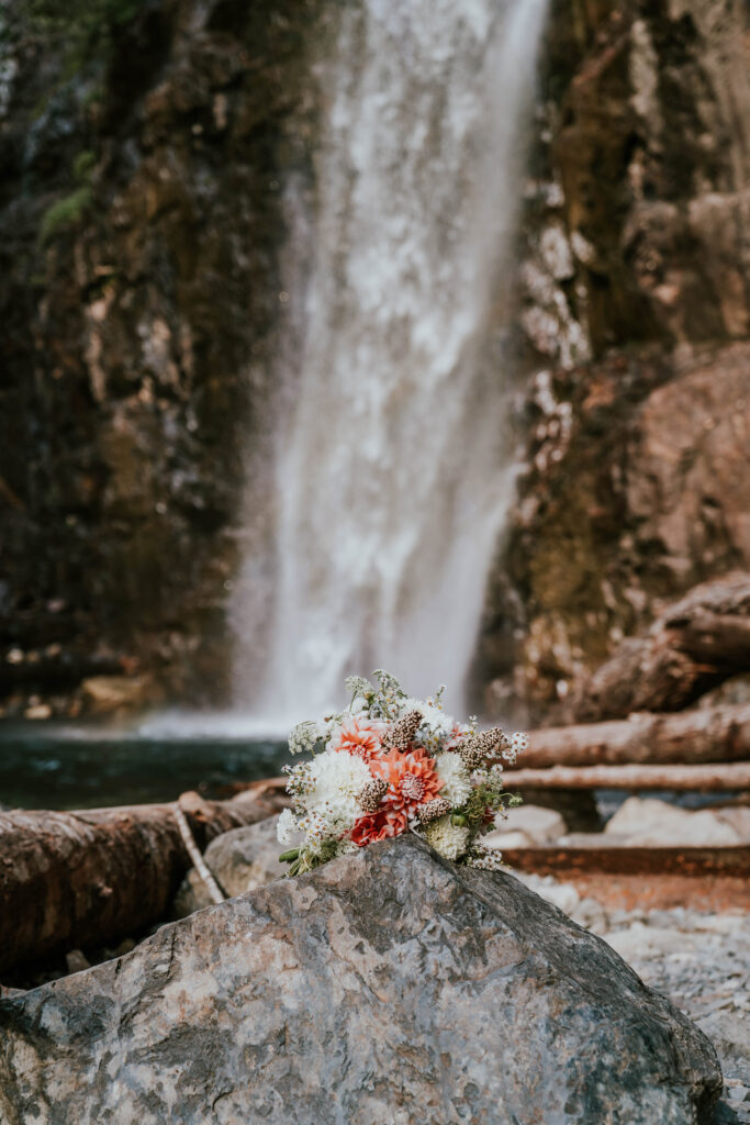 Bride's bouquet on a rock with the waterfall in the background