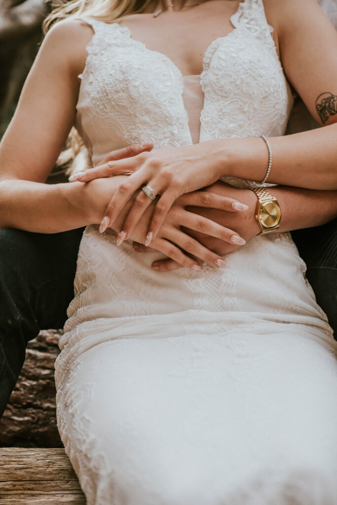 Groom wrapping hands around bride with bride's wedding ring as focus