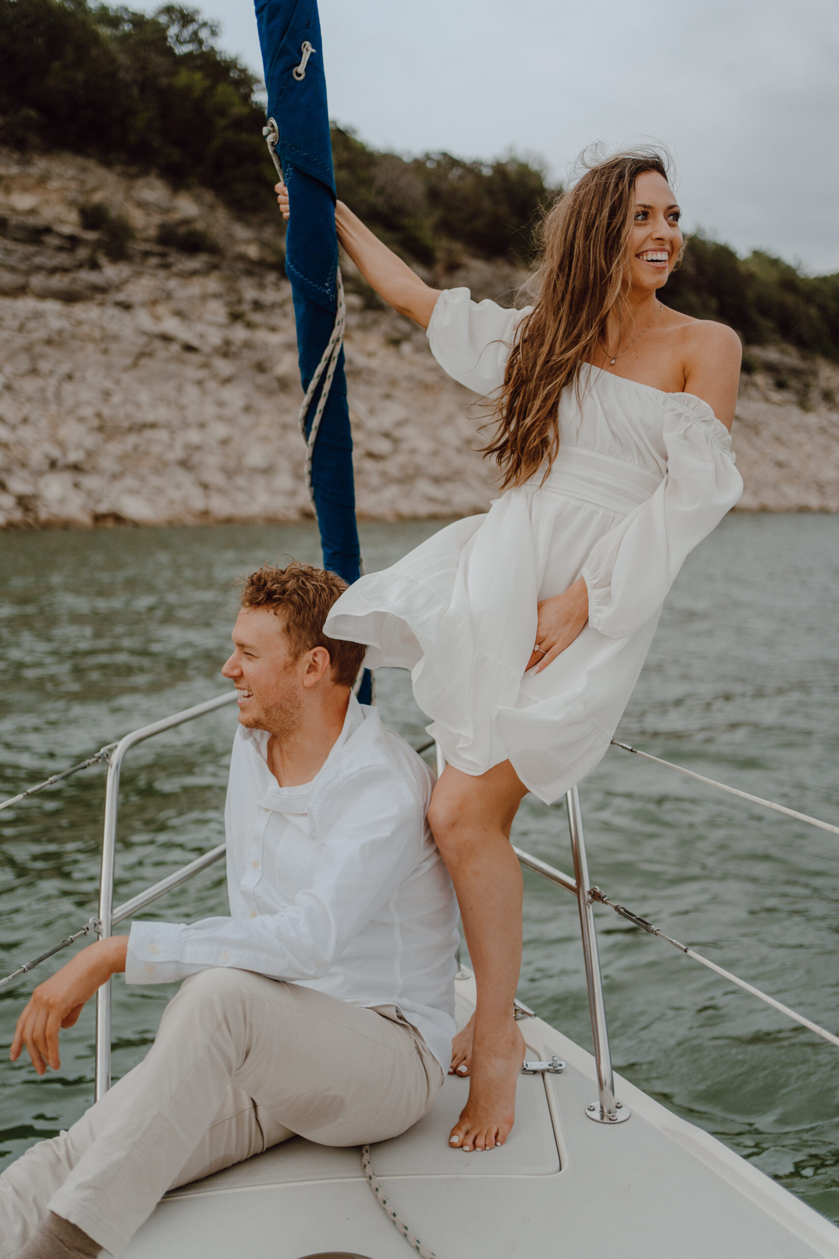 Engaged couple posing on sailboat for engagement photos