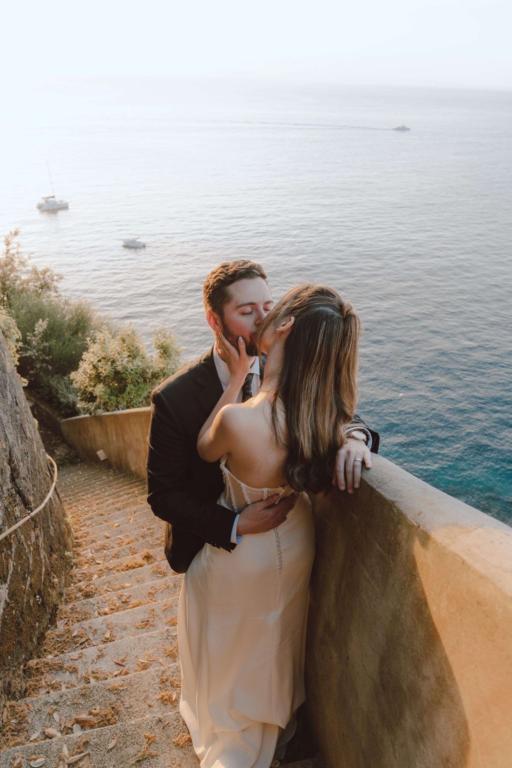 A bride and groom kissing and overlooking the Gulf of Naples in Sorrento, Italy