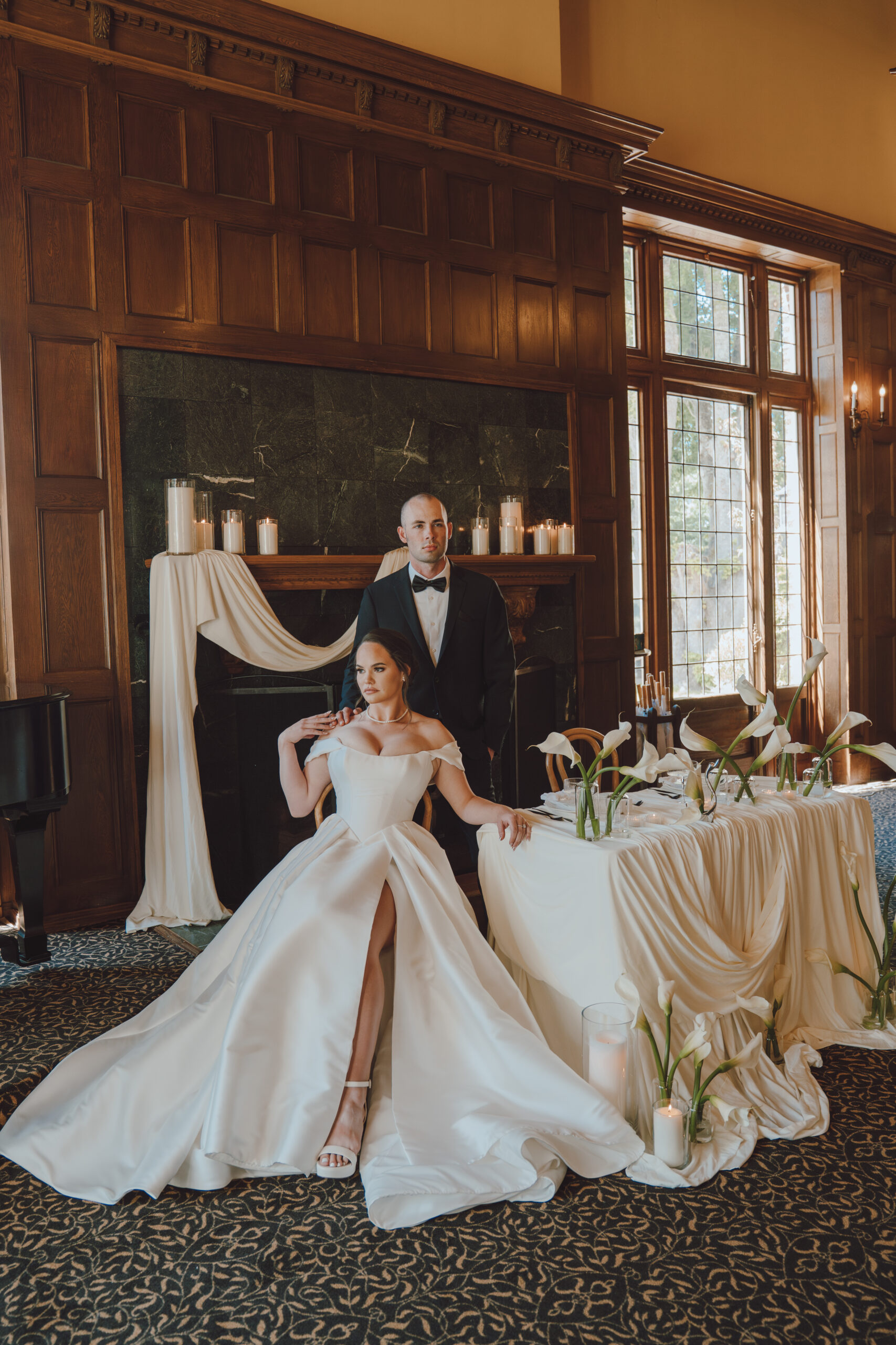 Bride and groom sitting at their sweetheart table encompassed in drapery